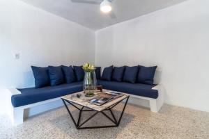 ein Wohnzimmer mit einem blauen Sofa und einem Tisch in der Unterkunft Cuale in Puerto Vallarta