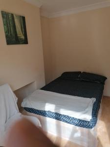 a small bedroom with a bed and a couch at Vob Property 76 in Hither Green