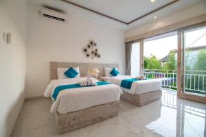 Dos camas en una habitación con balcón. en Villa Sayang Sanur III, en Sanur 43 fotos más