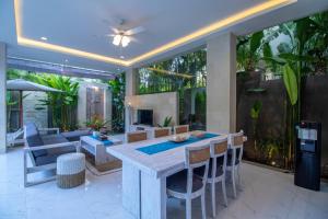 sala de estar al aire libre con mesa y sillas en Villa Sayang Sanur III, en Sanur