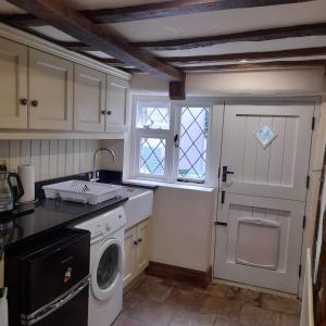 a kitchen with a washing machine and a window at Cosy Georgian Cottage in the Heart of Bewdley, Worcestershire in Bewdley