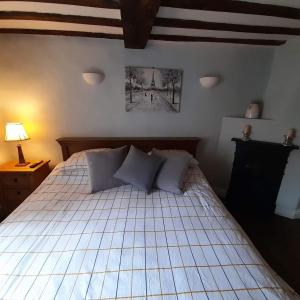 a bedroom with a bed with white sheets and pillows at Cosy Georgian Cottage in the Heart of Bewdley, Worcestershire in Bewdley