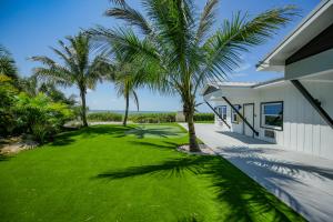 威尼斯Casey Key Resorts - Beachfront的一座房子前面的庭院,里面种有棕榈树