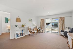 een woonkamer met een bank en een tafel bij Karori Kabin - Karori Holiday Home in Wellington