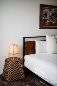a bedroom with a bed and a lamp next to it at The Good House- Hot Spring Hideaway in Desert Hot Springs