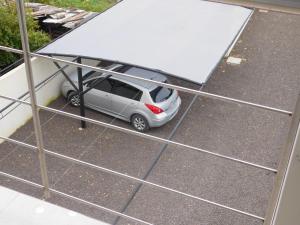 un coche pequeño está aparcado bajo una valla grande en Juana I en Villa Elisa