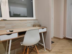 - Escritorio blanco con silla blanca en una habitación en Montanara2 en Parma
