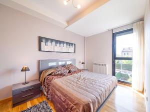 a bedroom with a bed and a large window at Belvilla by OYO Cirue a Campo de Golf in Cirueña