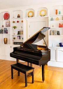 a black piano in a room with shelves at The Inn on First in Napa