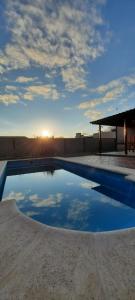 una piscina con el sol reflejo en el agua en Cabañas El Aromo en 