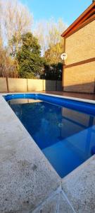 una piscina junto a un edificio con un aro de baloncesto en Cabañas El Aromo en 