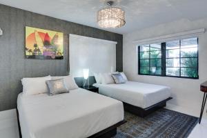 a bedroom with two beds and a chandelier at Bars B&B South Beach Hotel in Miami Beach
