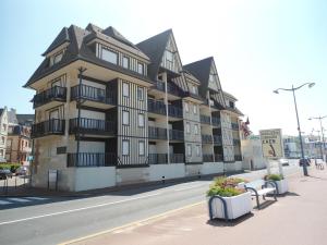 un grand bâtiment sur le côté d'une rue dans l'établissement Résidence Brise de Mer, à Villers-sur-Mer