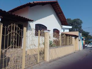 a fence in front of a white house at Bela Casa no Morro Chic - Itajubá - MG - Brasil in Itajubá