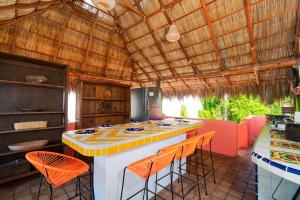 een keuken met een eiland met oranje krukken bij Villas Jardin Del Mar in Cruz de Huanacaxtle