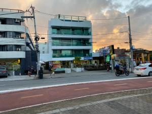 a person riding a motorcycle down a city street at Israel Flat Tambaú in João Pessoa