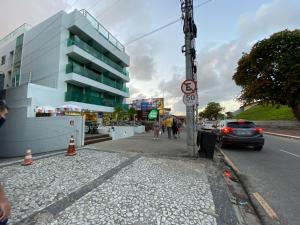 a street with a building and a car on the road at Israel Flat Tambaú in João Pessoa