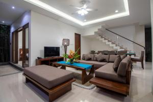 een woonkamer met een bank en een tv bij Villa Sayang Sanur IV in Sanur
