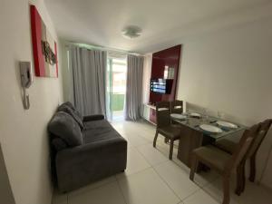a living room with a couch and a dining room table at Israel Flat Tambaú in João Pessoa