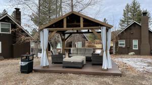een tuinhuisje met een bank en stoelen op een terras bij Bay Meadows Resort in Big Bear Lake