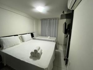 a bedroom with a bed with two towels on it at Israel Flat Tambaú in João Pessoa