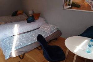1 dormitorio con 2 camas, mesa y silla en Apartament wysokim standardzie en Kwidzyn