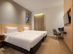 Säng eller sängar i ett rum på Hotel 88 Blok M Jakarta By WH