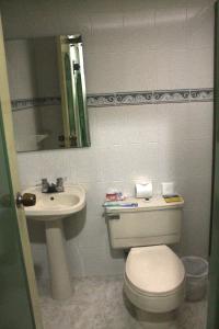 a bathroom with a toilet and a sink at Lafont Park Hotel in Bogotá