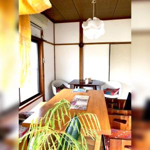 ein Esszimmer mit einem Holztisch und Stühlen in der Unterkunft 一棟貸切糸島リトリートハウスヨガ凪海近駅近 in Itoshima