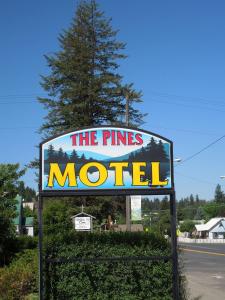 un panneau pour le motel des pins devant un arbre dans l'établissement The Pines Motel, à Saint Maries