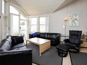 ロッケンにある10 person holiday home in L kkenのリビングルーム(黒革の家具、テーブル付)