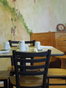 een tafel met twee stoelen en een tafel met kopjes en schotels bij The Pines Motel in Saint Maries