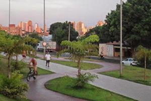 a man riding a bike down a path in a park at Pousada Recanto Alaketu Hospedagens in Campo Grande