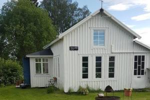 a white barn with a large window on the side of it at Loftstuga i Säfsen in Fredriksberg