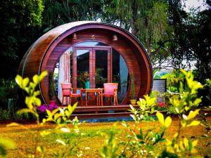 a circular building with a table and chairs in a garden at Regenta Resort Soma Vine Village Nashik in Nashik