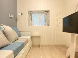 a living room with a couch and a flat screen tv at K,K,House in Osaka - Vacation STAY 69352v in Osaka