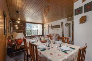 ein Esszimmer mit einem Tisch mit Stühlen und Tischdecken in der Unterkunft Appartement L'Outa 111 - Happy Rentals in Chamonix-Mont-Blanc