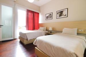 een hotelkamer met 2 bedden en een raam bij Pejaten Valley Residence in Jakarta
