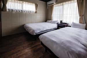 een kamer met 2 bedden en een raam bij LEGO in Uruma