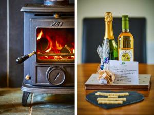 a bottle of wine and two bottles of champagne in front of a stove at Hazel Lodge in Blairgowrie