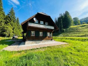 a small wooden house in a grassy field at Chalet anno 1794 in Rettenegg