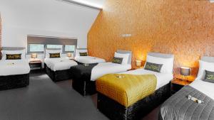 um quarto de hotel com quatro camas num quarto em The Leeds Gathering - Hot Tub - EV Charging em Leeds