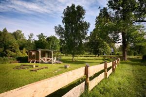 una valla frente a una cabaña en un campo en maringotka Aluna - České Švýcarsko, en Staré Křečany