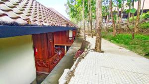 uma casa com um telhado azul ao lado de um passeio em Kasuari Exotic Resort Magelang em Magelang