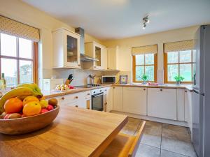 a kitchen with a bowl of fruit on a wooden table at Holly House in Blairgowrie