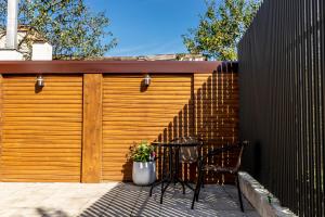 a wooden garage door with a table and chairs on a patio at Corvin Guesthouse in Hunedoara