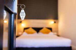 sypialnia z łóżkiem z żółtymi poduszkami i łańcuchem na klucze w obiekcie Corvin Guesthouse w mieście Hunedoara