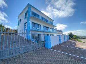 una casa azul y blanca con una valla en Blue Star Villa, en Tergniet