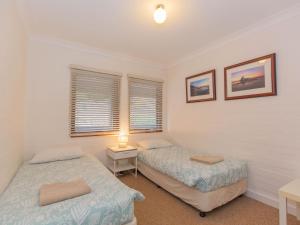 two beds in a room with two windows at Dauphine 1 23 Townsend Street in Jindabyne