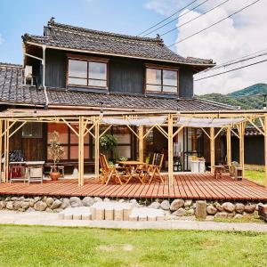 a house with a wooden deck in front of it at Fam in Yazu